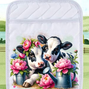 Pode incluir: Pegador de panela acolchoado branco com uma vaca preta e branca usando uma coroa de flores rosa e segurando um regador com flores rosas. A vaca está ao lado de outra vaca preta e branca com flores rosas.