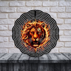 May include: A metal wind spinner with a circular design featuring a tiger's face surrounded by flames. The background is black with a swirling pattern.