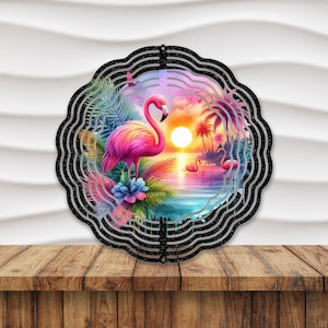 May include: A metal wind spinner with a colorful design featuring pink flamingos, palm trees, and a sunset. The spinner has a black background with silver glitter accents.