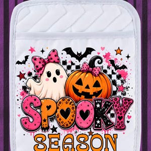 May include: A white quilted pot holder featuring a graphic print of a ghost and a pumpkin, both wearing pink patterned bows. The design includes black bats, stars, and hearts, with the text SPOOKY SEASON in large, colorful, patterned lettering.