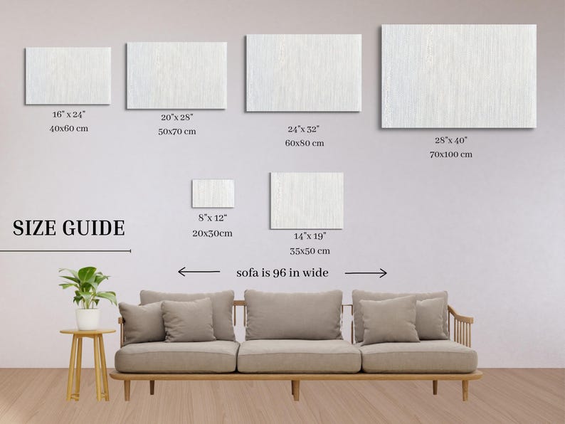 May include: A size guide for wall art, showing different sizes of canvas prints with measurements in inches and centimeters. The guide also shows a sofa that is 96 inches wide.