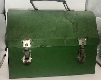 May include: A vintage green metal lunch box with a silver handle and two silver latches. The lunch box has a slightly worn, distressed look.