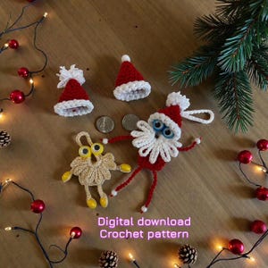 May include: A selection of handmade Christmas crochet decorations, featuring red Santa hats and a Santa Claus figure with a white beard and blue eyes. A small, beige crocheted figure with yellow eyes and feet is also present. Text reads "Digital download Crochet pattern".