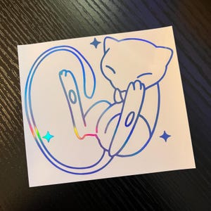 May include: A white sticker featuring a blue outline of a cartoon cat-like creature in a curled position. The outline has a holographic, rainbow-colored sheen in some areas. Four blue star shapes are around the creature.