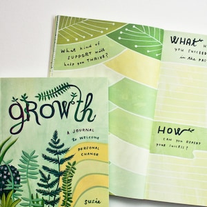 May include: A green and yellow journal with the word "growth" in large, stylized lettering. The cover features a colorful illustration of plants and the text "A journal to welcome personal change". The journal is open to a page with the text "What has helped you succeed in the past?" and "How can you repeat your success?"