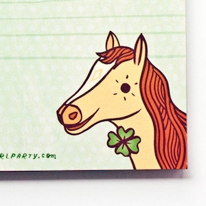 Op de afbeelding: Groen gestreept notitieblok met een bruine touwrand en een cartoonpaard met een klavertje vier op zijn nek. Het notitieblok heeft de tekst "&copy; BOYGIRLPARTY.COM" onderaan.
