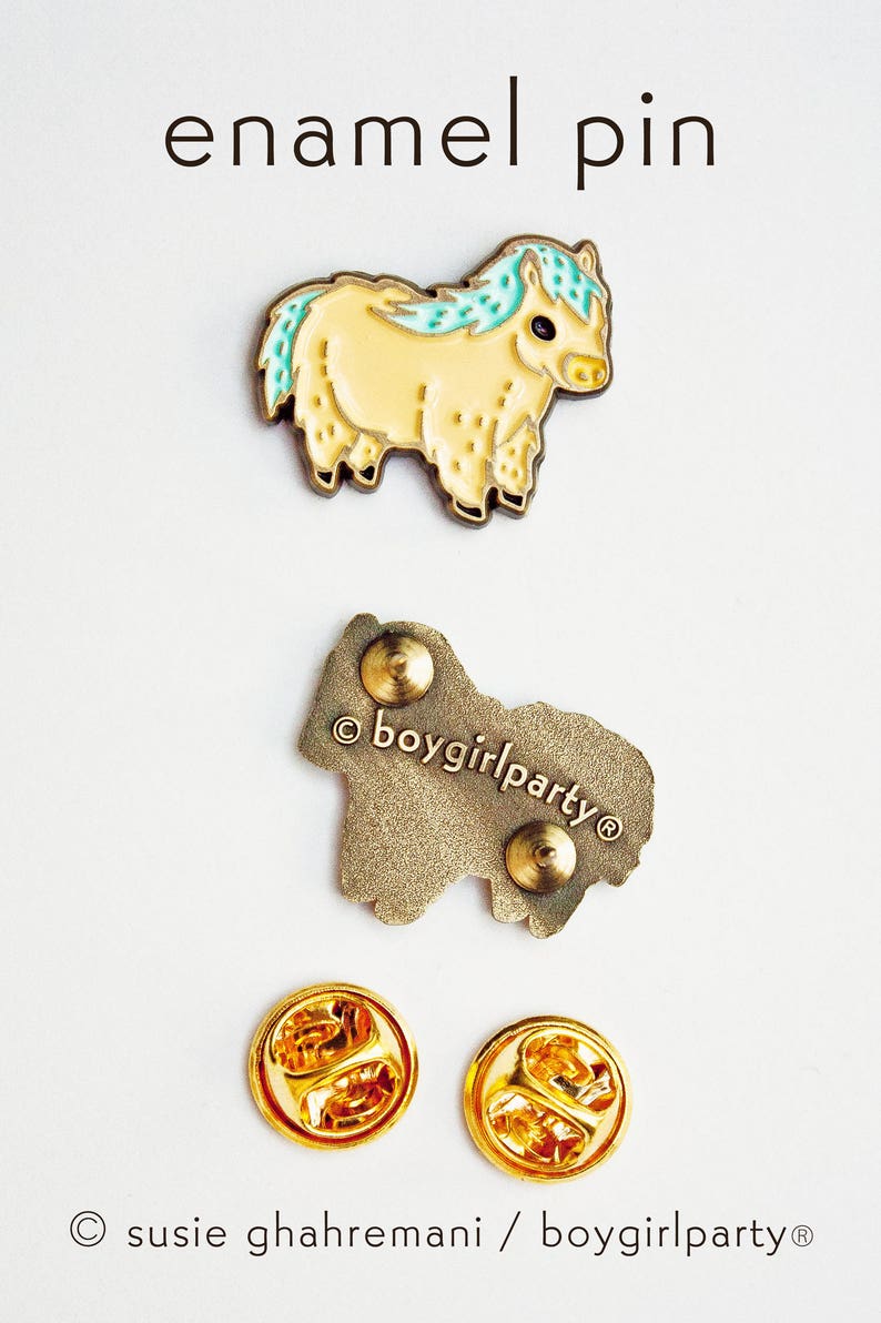 Op de afbeelding: Emaille pin met een cartoon gele pony met een blauwe en groene manen en staart. De pin heeft een gouden afwerking en is bevestigd aan een gouden metalen achterkant met een veiligheidsspeld. De achterkant is gestempeld met de tekst "&copy;boygirlparty&reg;".