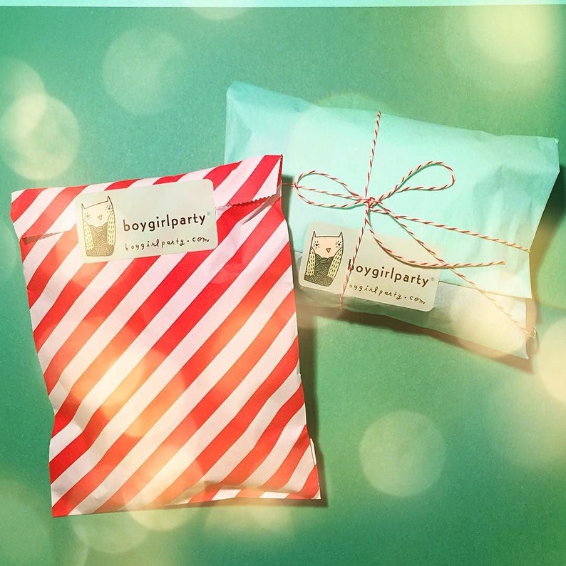 May include: Two gift bags, one red and white striped and one light blue, both with a white sticker with a cartoon cat and the text "boygirlparty boygirlparty.com".
