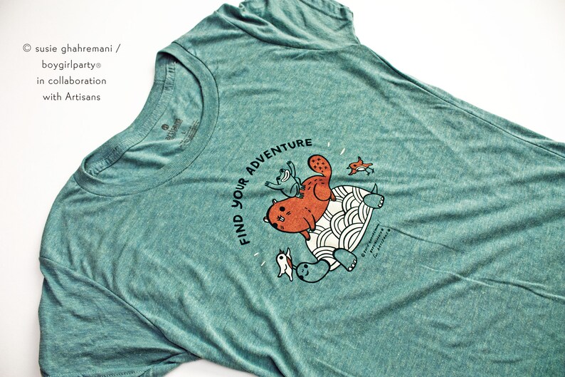 May include: Teal blue t-shirt with a graphic of a cat riding a turtle with the text "Find Your Adventure".