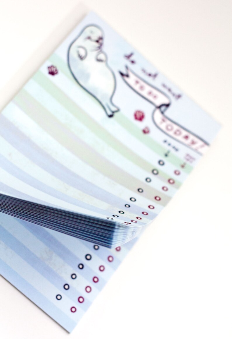 May include: A notepad with a light blue striped design and a cartoon seal illustration. The notepad has a banner that says "do not want to do today!" with check boxes. The notepad is on a white background.