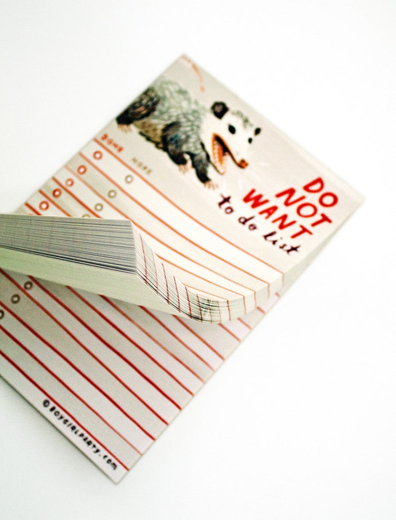 May include: A white notepad with red lines and a black and white illustration of a possum. The notepad has the text "DO NOT WANT to do list" printed on the front.