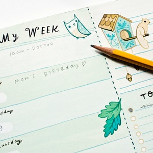 May include: A weekly planner with a green and blue color scheme. The planner has a section for each day of the week, with space for writing appointments and tasks. The planner also has a to-do list section. The planner is decorated with illustrations of an owl, a birdhouse, and a squirrel.