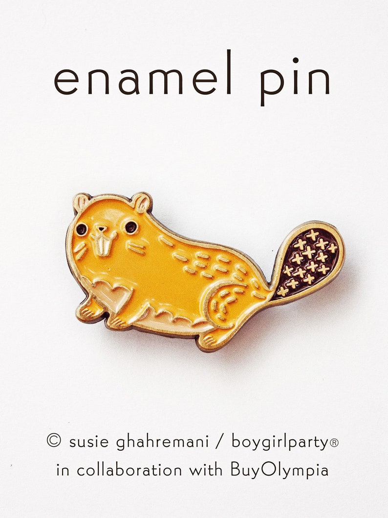 May include: A yellow enamel pin of a cartoon beaver with a brown tail. The pin is a cute and whimsical design, perfect for animal lovers.