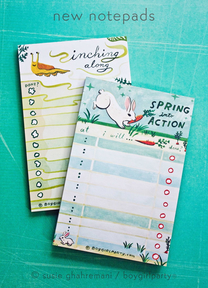 May include: Two green and blue notepad sets with illustrations. One notepad features a snail with the text "inching along" and the other notepad features a white rabbit with the text "Spring into Action".