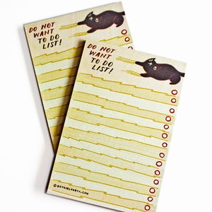 May include: A notepad with a black cat illustration and the text "Do Not Want To Do List!" on each page. The notepad has a yellow and white striped background.
