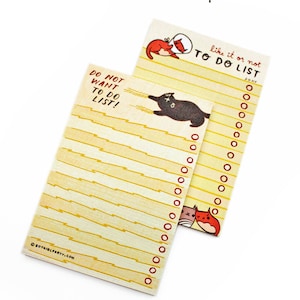 May include: Two yellow to-do list notepads with black and red cat illustrations. The notepad on the left has the text "Do Not Want To Do List!" and the notepad on the right has the text "Like it or not To Do List" with a check box labelled "Done".