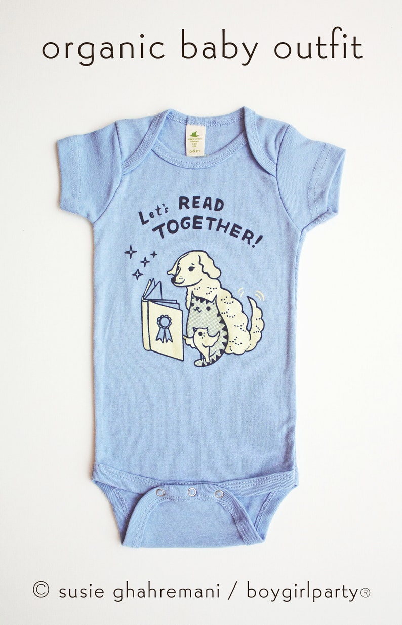 May include: A light blue baby onesie with a graphic of a dog and cat reading a book. The text on the onesie says "Let's Read Together!"