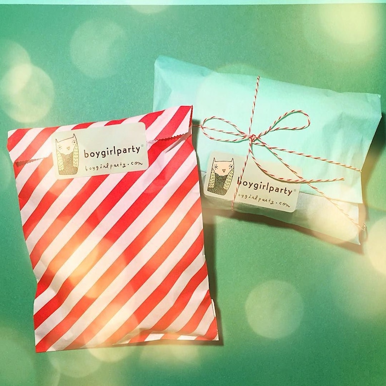 May include: Two gift bags, one red and white striped and one light blue, both with a white label that says "boygirlparty boygirlparty.com".