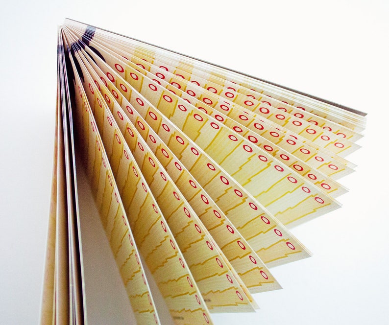 May include: A stack of yellow paper with red circles printed on it. The paper is folded in a fan shape.