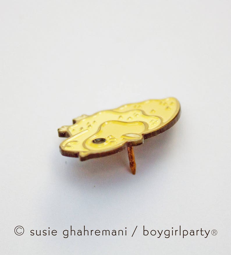 May include: A yellow enamel pin with a cartoon-style illustration of a yellow chick. The pin has a gold finish and a back pin.