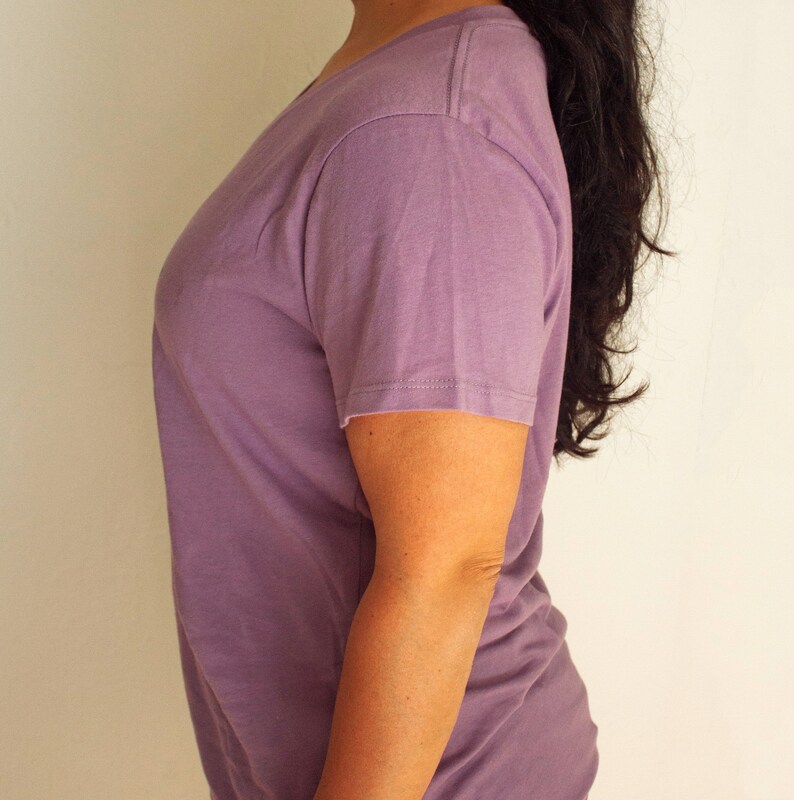 May include: A plain, light purple t-shirt with a v-neck and short sleeves.