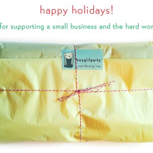 May include: A yellow gift wrapped in tissue paper and tied with red string. The package has a small square label with the text "boygirlparty" and a website address. The text "yes, i'll wrap it! happily! no charge." is written in green on a white background.