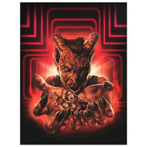 Op de afbeelding: Een horrorprint met een demonische figuur met hoorns en scherpe tanden die een schreeuwende persoon in zijn handen vasthoudt. Het kunstwerk is geplaatst tegen een rode en zwarte geometrische achtergrond, wat een dramatisch en intens beeld creëert.