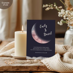 May include: A navy blue wedding invitation with a watercolor crescent moon design. The invitation reads "Emily & Daniel" and includes the text "Together with their family are inviting you to join them for the celebration of their wedding. Reception to follow."