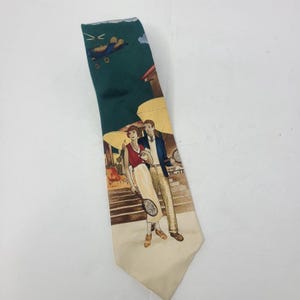 May include: A dark green necktie featuring a printed illustration of a person in a red top and white skirt holding a tennis racket, standing next to a person in a blue blazer and tan trousers, with a small blue helicopter flying above.