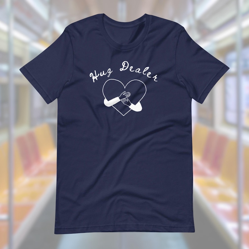 May include: A navy blue t-shirt with a white heart graphic and the text "Hug Dealer" printed on the front.