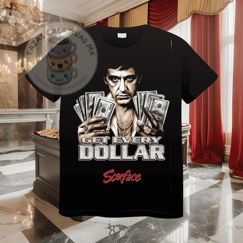 Pode incluir: Camiseta preta com um gr&aacute;fico de um homem segurando pilhas de dinheiro. O texto "Get Every Dollar" e "Scarface" est&atilde;o impressos na camiseta.
