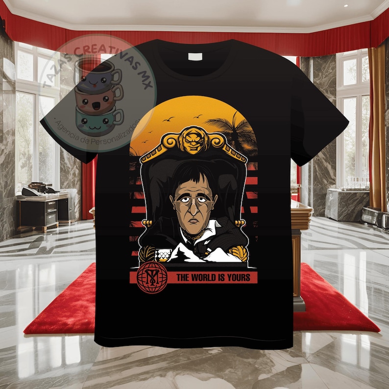 Pode incluir: Camiseta preta com um gr&aacute;fico de um homem sentado em um trono com um fundo de p&ocirc;r do sol. O texto "The World Is Yours" &eacute; impresso abaixo da imagem.