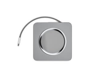 Puede incluir: Un dispositivo cuadrado de color plateado con un centro circular y un cable delgado y curvado que se extiende desde la parte superior. El centro es un tono de gris más claro, creando un contraste con la plata circundante.