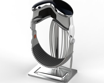 Puede incluir: Un dispositivo futurista plateado y negro con un diseño curvo, con una sección superior negra y una banda inferior gris y acanalada. El dispositivo está montado en un soporte plateado con una base rectangular, lo que sugiere una estación de carga.