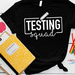 May include: Black t-shirt with white text that says "Testing Squad" with a pencil graphic above the text.