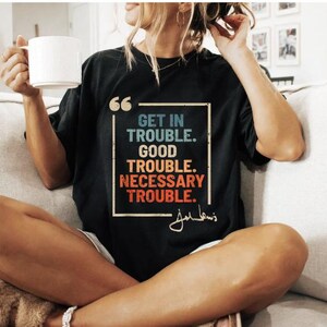 May include: Black t-shirt with a quote by John Lewis in a vintage style font. The quote reads "Get in trouble. Good trouble. Necessary trouble."