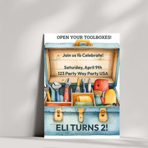 May include: Watercolor illustration of a blue toolbox invitation. The invitation reads "Open Your Toolboxes!" and "Join us to Celebrate!" with event details. The toolbox is open, revealing various tools. The text "ELI TURNS 2!" is at the bottom.