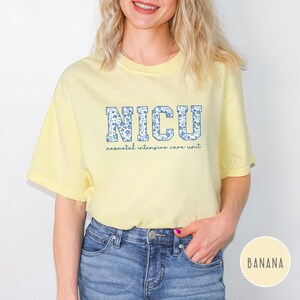 May include: A yellow t-shirt with the text "NICU" in blue and white letters with a floral pattern. The text "neonatal intensive care unit" is printed below the letters.