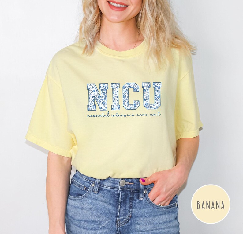 May include: A yellow t-shirt with the text "NICU" in blue and white letters with a floral pattern. The text "neonatal intensive care unit" is printed below the letters.