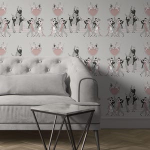 May include: A gray wallpaper featuring a repeating pattern of dancing couples in black, pink, and gray, with a pink shield design. A gray sofa with a rectangular pillow and a black metal side table with a marble top are in the foreground.