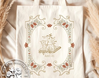 Può includere: Una borsa tote in tela bianca con un design dorato e rosso che presenta un agnello con uno stendardo che recita "Agnus Dei". Il design è incorniciato da un bordo decorativo.
