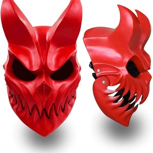 Könnte beinhalten: Zwei rote Plastik-Dämonenmasken mit scharfen Zähnen und Hörnern. Die Masken haben eine glänzende Oberfläche und sind so konzipiert, dass sie das gesamte Gesicht bedecken.