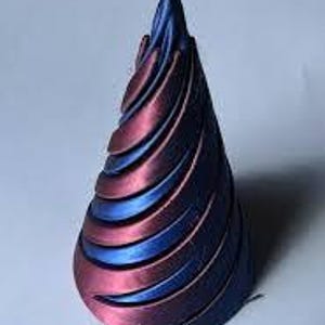 May include: A cone-shaped, decorative object with a swirling pattern. The object is made of a dark blue and burgundy material.