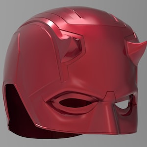 Puede incluir: Un casco de superhéroe rojo brillante con un diseño elegante. El casco presenta una prominente línea de cejas, aberturas para los ojos y cuernos puntiagudos distintivos. La forma general es aerodinámica.