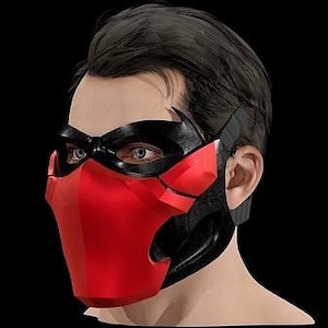 Puede incluir: Una máscara facial roja y negra con un diseño geométrico. La máscara cubre la nariz y la boca y tiene una pequeña abertura para los ojos.