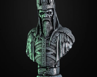 May include: A silver bust of a king wearing a crown with intricate details. The king has a long beard and a stern expression. The bust is set on a base with skulls and is illuminated with green and blue lighting.