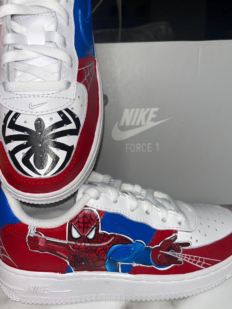 May include: A white ceramic mug with a black handle and the text "But First, Coffee" in a bold, black font. The mug is set against a blurred background, suggesting a cozy setting.