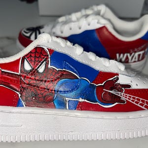 May include: A set of three ceramic mugs with a speckled, cream-colored glaze. Each mug features a different hand-painted floral design in shades of blue, green, and yellow. The mugs have a simple, rounded shape.