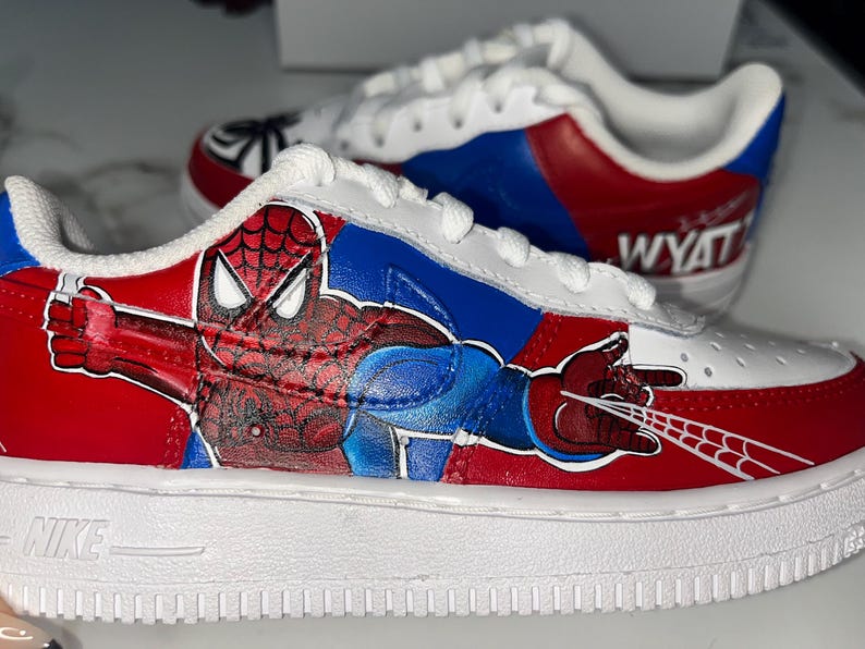 May include: A set of three ceramic mugs with a speckled, cream-colored glaze. Each mug features a different hand-painted floral design in shades of blue, green, and yellow. The mugs have a simple, rounded shape.