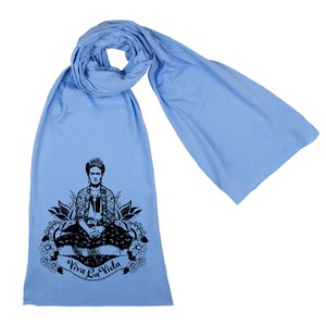 May include: A light blue scarf with a black and white illustration of Frida Kahlo sitting with the text "Viva La Vida" printed on it.